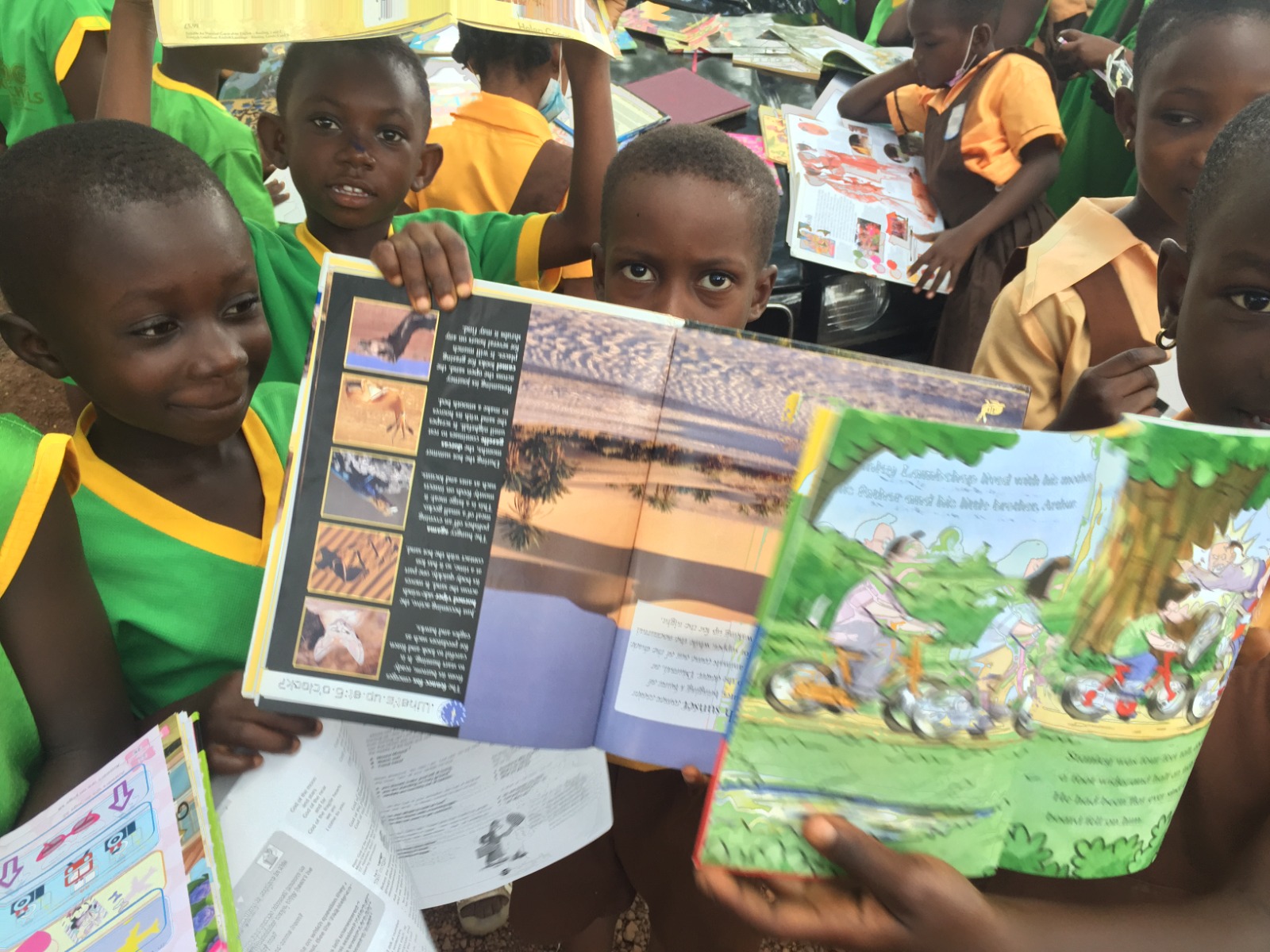 Children hold up donated storybooks