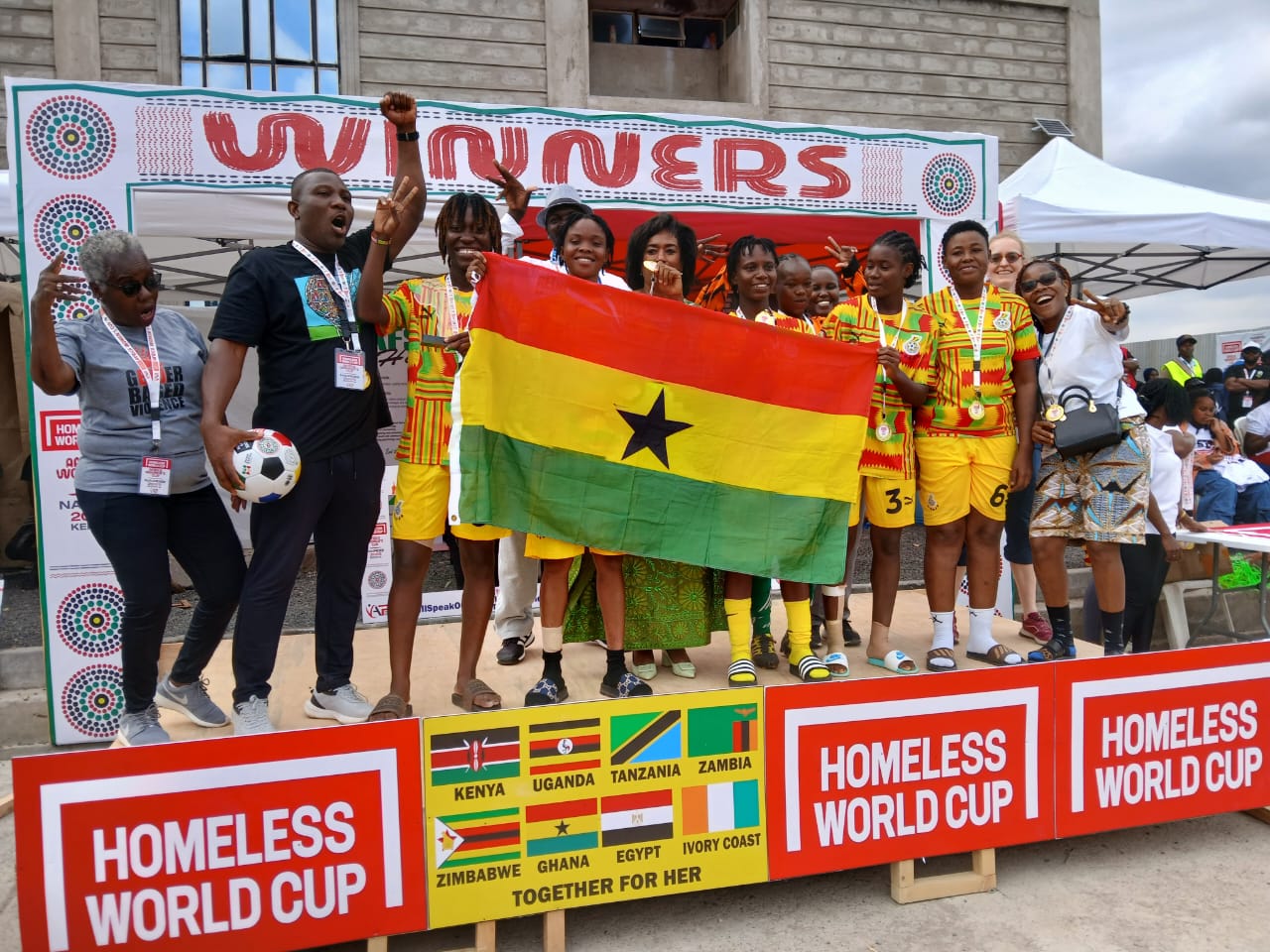 Ghana team celebrating with the flag on the Homeless World Cup winners podium